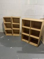 Two bookshelves, one with three compartments the other with four, both with adjustable shelves. Shelves appear well used with scuffs and marks at base.