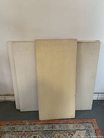 Five vintage canvases stacked with one in front, showing wooden stretcher bars and aged canvas surfaces