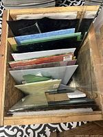 Wooden crate containing multiple stained glass sheets in various colors and sizes