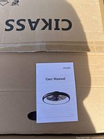 User manual showing front cover featuring image of the ceiling fan and brand name CIKASS
