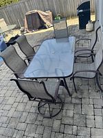 Full view of table and six chairs on patio.