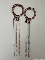 Full view of both Maasai-style beaded necklaces hanging to show length and bead strands