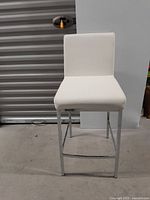 Front view of white faux leather kitchen bar stool showing seat and backrest.