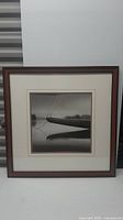 Full image of the framed black and white canoe photograph showing the frame and matting.