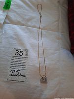 Full view of unmarked gold chain with heart pendant laid flat