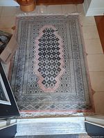Full view of the wool and silk area rug showing central medallion and overall pattern.