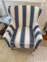 Front view of striped armchair showing full shape and upholstery pattern