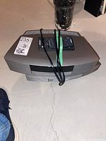 Top view of Bose system base unit with two remotes taped on top