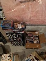 Photo of stacked CDs and DVDs, some in cardboard boxes, in basement storage setting