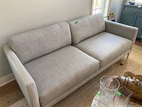 Full front-left angled view of the sofa showing overall shape and cushion arrangement