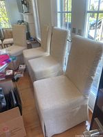 Three of the four chairs lined up near glass doors