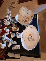 Wide view showing porcelain bowl with applied florals set next to other decorative items