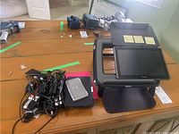 Overall view of Kindle e-reader, Samsung Galaxy Tab 2 tablet on Fellows laptop stand, cables and Casio device on wood table