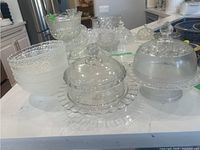 Wide view of assorted clear glass bowls and lidded dishes on countertop