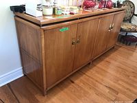 View of the full buffet cabinet showing overall build and finish with visible items on top and the side panel.