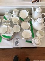 Overview showing all items: teacups, saucers, bouillon bowls, coffee pots, creamer and sugar bowl.