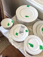 Wide shot of stacked dinner plates, salad plates, side plates and bowls on a table.