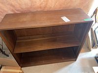 Front view showing bookshelf with three shelves and rectangular shape.