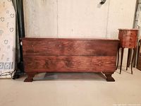Front view of vintage wooden chest showing rectangular shape and dark wood finish.