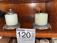 Both salt cellars side by side on wood shelf with lot marker