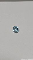 Top view of the cushion cut aquamarine gemstone showing its seafoam blue color and clarity.