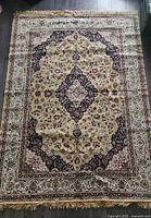 Top-down view of the full rectangular Persian rug showing ivory floral designs and various colors with a central medallion.