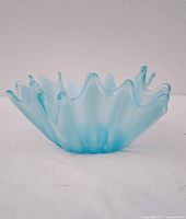 Front view of blue opalescent glass handkerchief vase showing wavy rim and overall shape