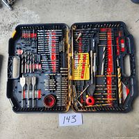 Full view of open black plastic case containing assorted drill bits and accessories arranged within red and yellow holders, labeled with sizes.
