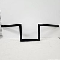 Front view of the black square motorcycle handlebar against a white background showing the overall shape and design.