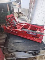 Side view of red hydraulic scissor lift on pickup bed showing 1500 lbs label
