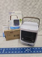 Chillwell air cooler unit, instruction manual, and box with brown handle and front vent with buttons.