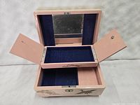 Open view of the jewelry box showing dark blue velvet lined interior, mirror on lid, and lift-out tray.