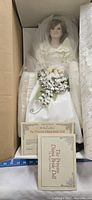 Full view of the Princess Diana wedding bride doll in the original box with certificate visible at the foot of the doll.