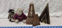 Lot showing two Boyds Bears, a wooden vintage metronome, and a wooden triangular bookend with geometric design.