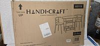 Box showing Handi-Craft branding and graphic of compact dining set with table and two chairs in light beech finish.