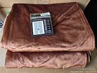 Folded brown velvet curtain panels stacked, showing texture and color