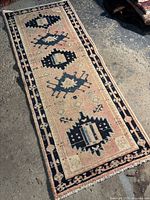 Full view of the small vintage style Gharajah runner rug laid flat, showing geometric designs and color scheme.