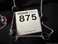 Close-up of Parklane purple beaded necklace with square purple stone pendants on silver chain