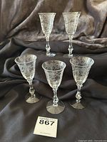 Full set of five Cambridge Portia claret glasses displayed together on a dark fabric background, showing overall design and condition.