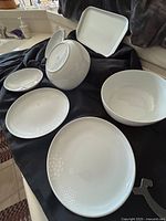 Set of white Kahla German china pieces including 2 plates, 2 bowls in box, 2 large bowls and a long rectangular plate, displayed on a black cloth in natural light.