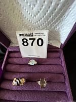 Three rings displayed in purple velvet jewelry holder, showing the different designs as per the set