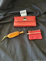 Photo of three items: large wallet, small coin purse, and wooden mouse accessory on black fabric background