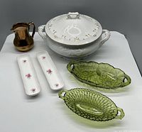 Lot showing all items: white covered serving dish, two green glass dishes, copper gold pitcher, two narrow floral dishes.