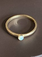 Ring on black background showing full band and opal