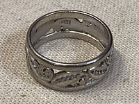 Ring on fabric background showing exterior design and interior hallmark.