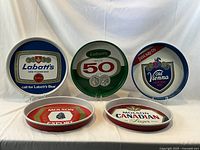 Photo showing all 5 vintage Canadian beer advertising serving trays with fronts visible.