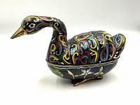 Profile side view of the brass cloisonné duck box showing colorful hand-enameled designs.