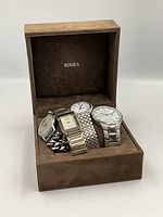 Four watches in brown Birks box, viewed from front showing the faces and bands.