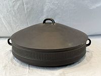 Covered round skillet dish with fluted brown exterior