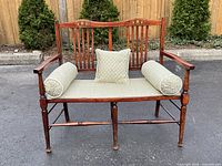 Full front view of Edwardian mahogany hall bench with seat cushion, two bolster pillows, and square cushion on bench seat.